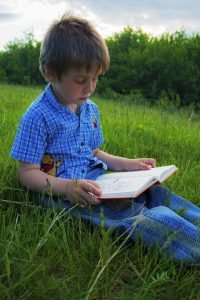 boy reading outdoors