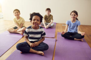 kids sitting on yoga mats