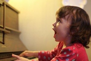 young girl singing and playing piano