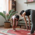 mother and daughter doing yoga at home