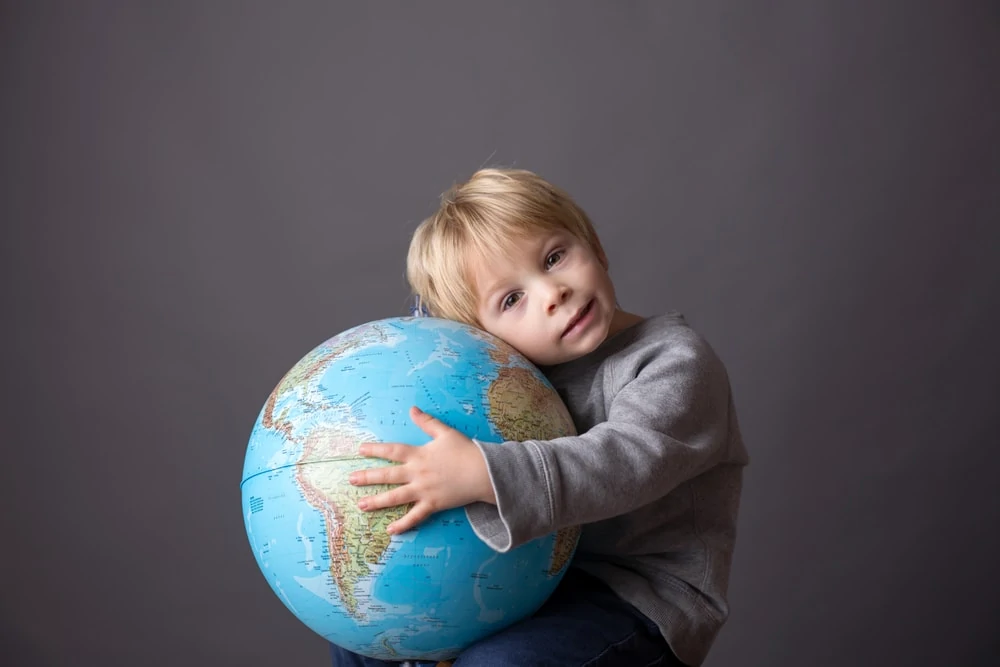 young boy hugging globe