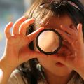 girl looking through photo lens