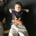 young boy with stuffed animal resting on belly