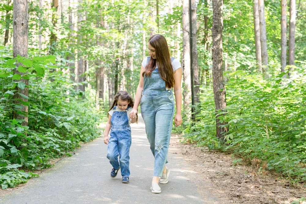 mother and daughter walking in forest