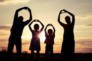 adults & kids in silhouette making heart symbols