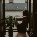 woman sitting in window gazing out