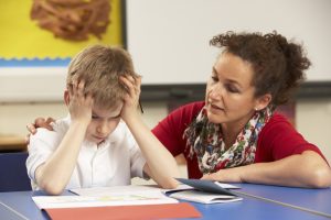 teacher talking with stressed boy