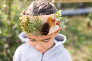 boy wearing crown decorated with natural materials