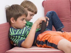 crianças caídas no sofá jogando videogame