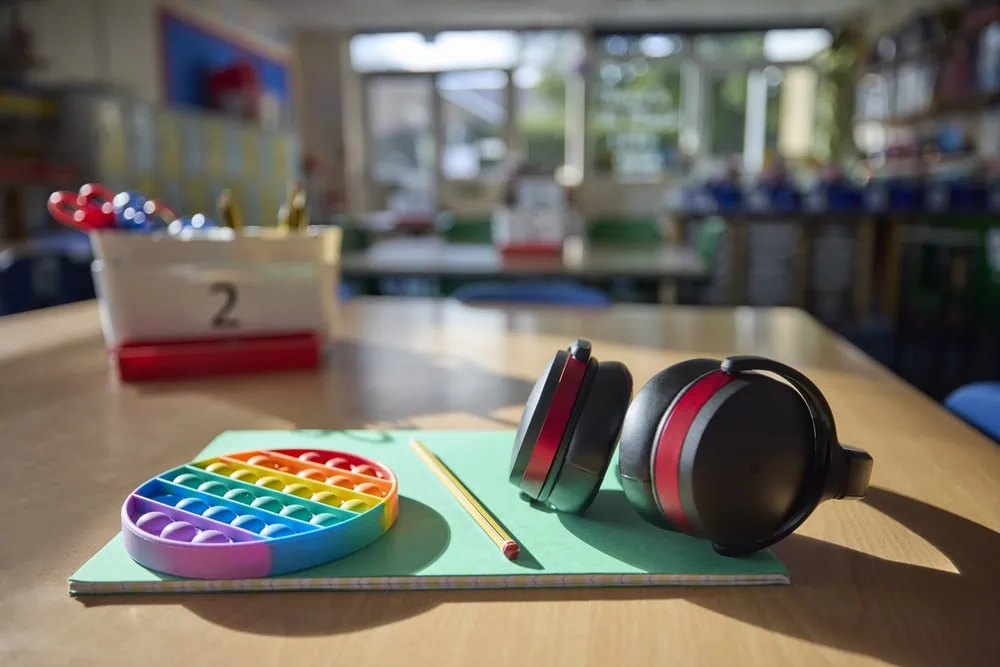 noise canceling headphones and fidget toy on classroom desk